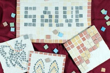 Mosaike auf roten Tuch mit Motiven: Salve, Hund, Sandalen